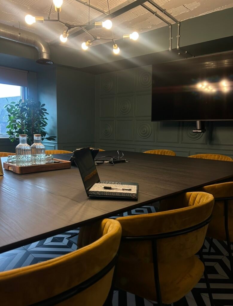 Flex workspace meeting room with laptop and notebook - commercial real estate jobs